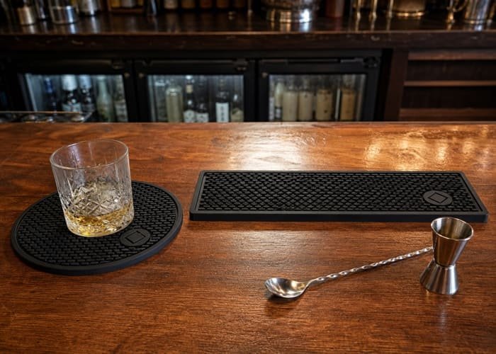A comparison of round and rectangular bar mat sizes on a wooden counter