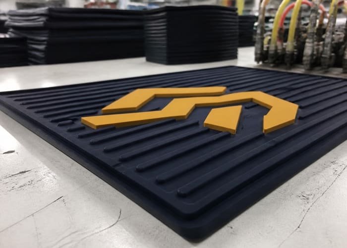 Magnified view of a 3D embossed logo on a PVC bar mat showing its raised texture and color contrast
