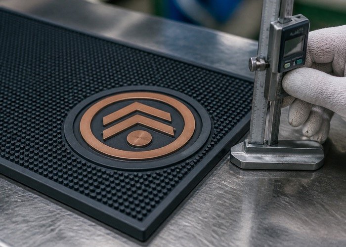 Detailed shot of an embossed logo on a PVC custom bar mat design