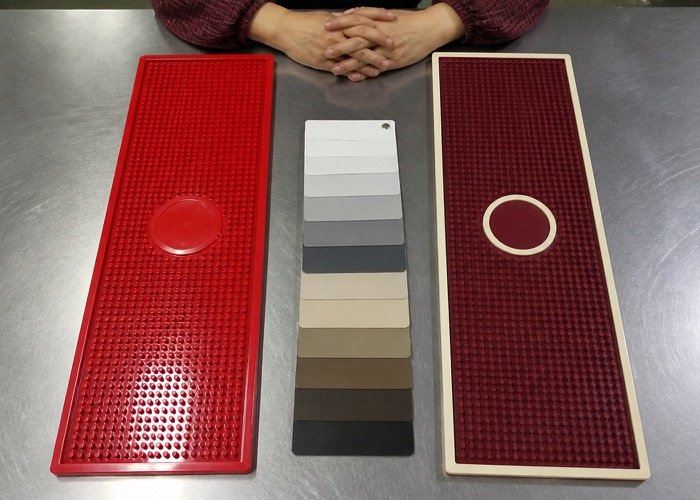 A comparison of a cheap-looking shiny red bar mat and a premium-looking matte maroon bar mat